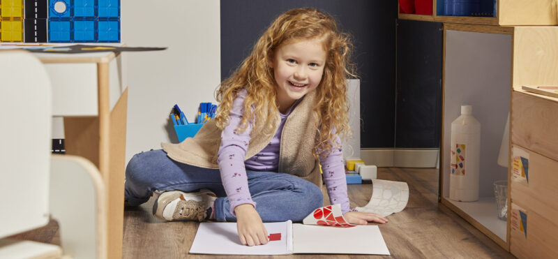 Meisje spelend met plakfiguren