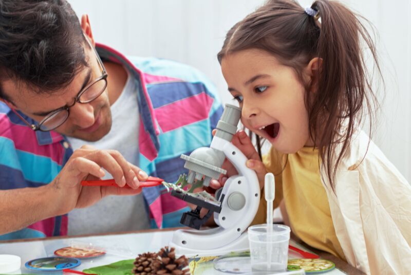 kind kijkend door een microscoop